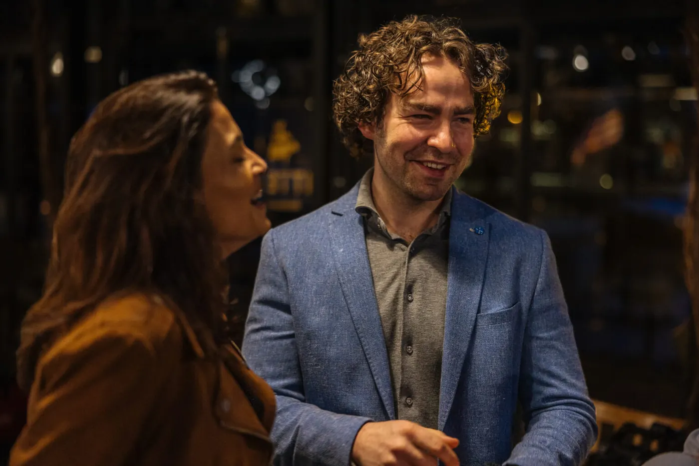 Een man en een vrouw van het team van Matchvermogen in gesprek aan een tafel. Foto gepubliceerd op matchvermogen.nl.